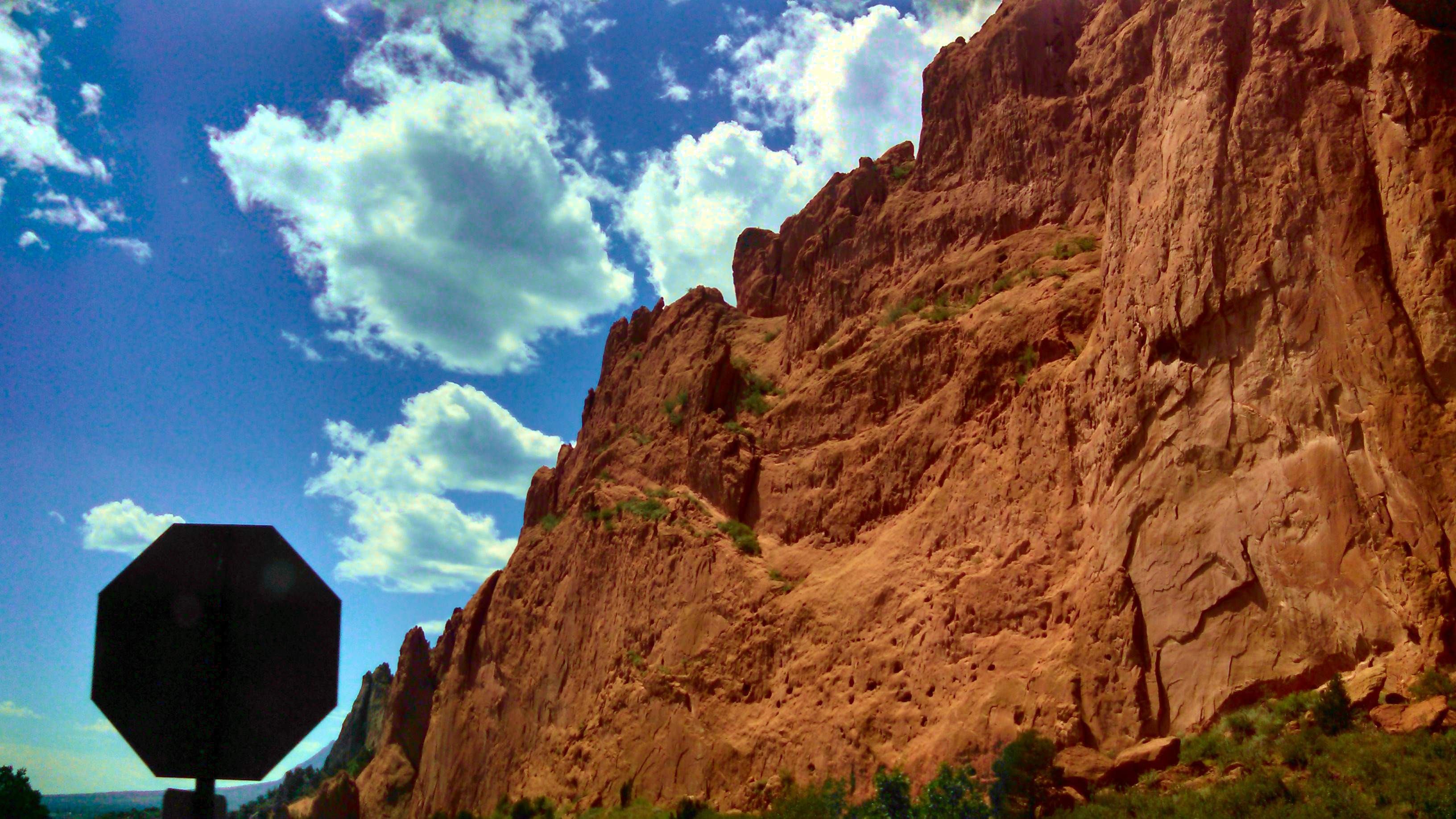 A red rock fills the bottom right half of the screen, and the sky in the top left. A stop sign is visible in silhouette on the bottom left