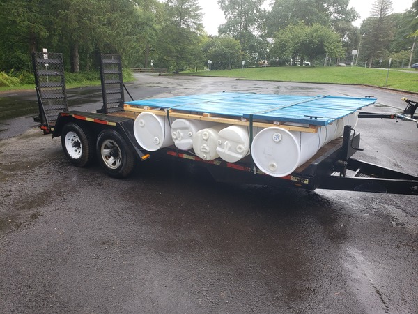 The boat loaded on a trailer. The boat's deck is the color of weezer's debut album. Everything is covered in rain
